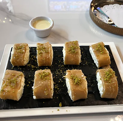 Cream-filled pastries topped with crushed pistachio